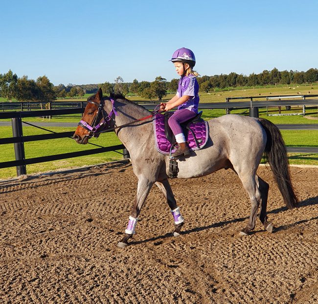 Small child rides on arena fenced with flexible rail Horserail is the safest choice for arena fencing as well as paddock fencing